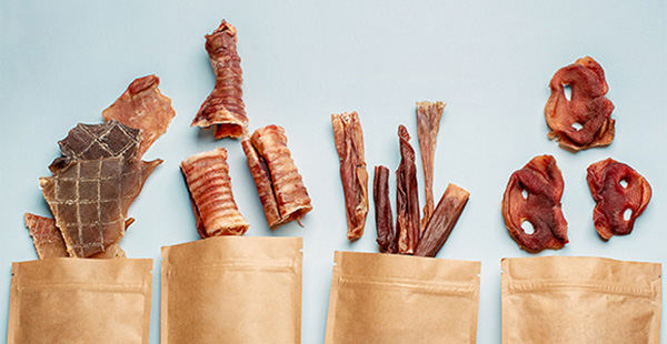 variety of dog treats arranged on display including jerky and chewy options in packaging designed for pet owners to choose from representing nine unique flavors
